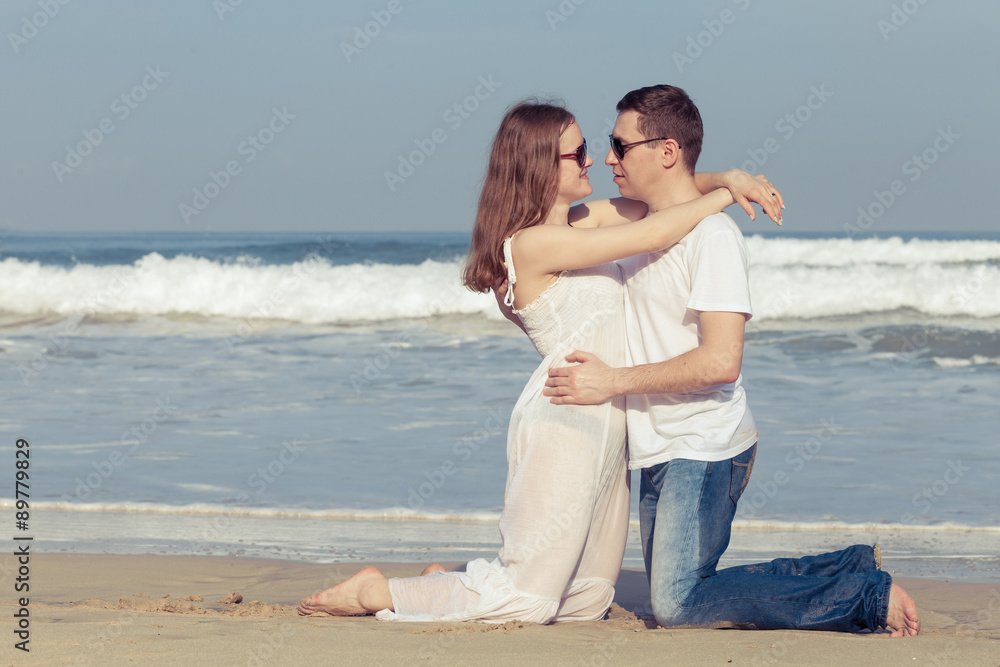 Loving couple standing on the beach at the day time. Loving couple standing on the beach at the day time.