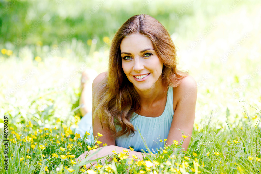 young woman in blue dress lying on grass young woman in blue dress lying on grass