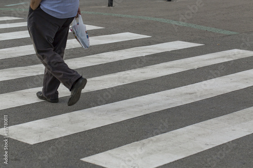 Legs of a man crossing a zebra crossing
