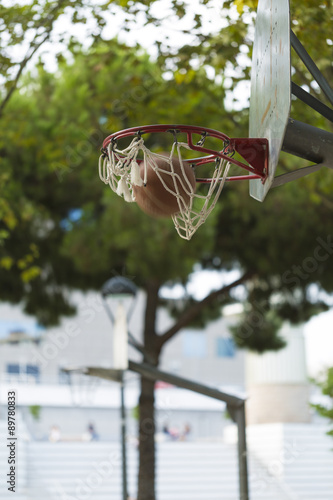 Basketball going through a hoop in a city park basketball court