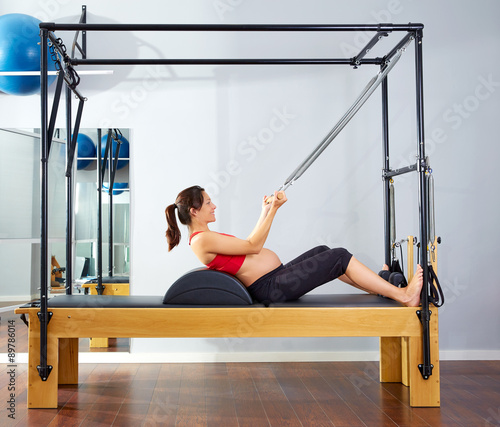 pregnant woman pilates reformer roll up exercise