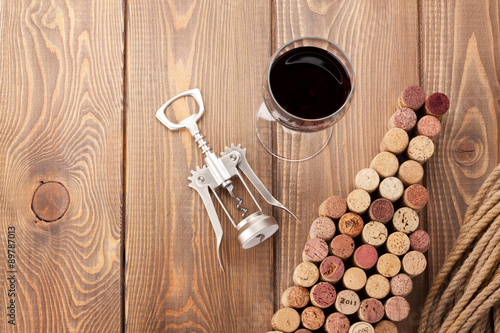 Wine bottle shaped corks, glass of wine and corkscrew