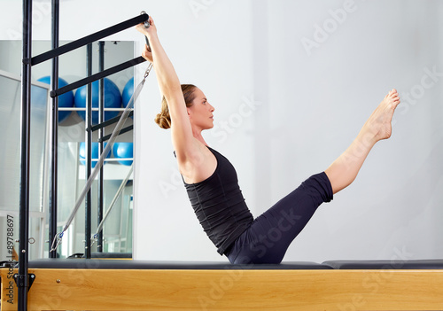 Pilates woman in reformer teaser exercise at gym photo