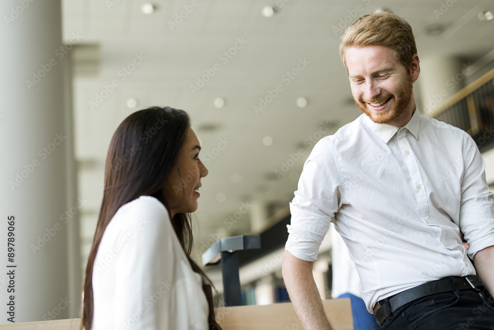 Obraz premium A group of academics studying in the library and conversing