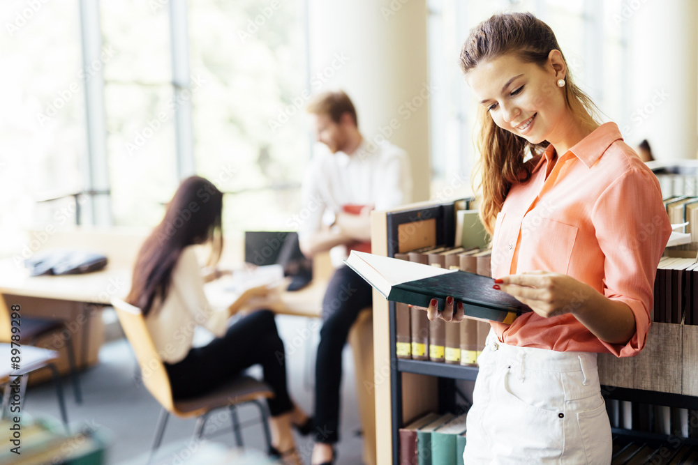 Beautiful woman reading a book in a library Beautiful woman reading a book in a library