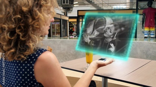 Hi-tech Concept. Woman Watching Video on Futuristic Hologramic photo