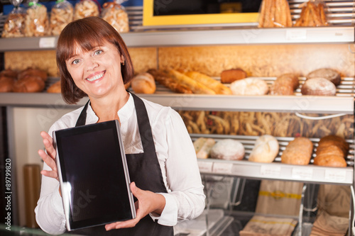 Pretty senior chef is using modern technology in bakery