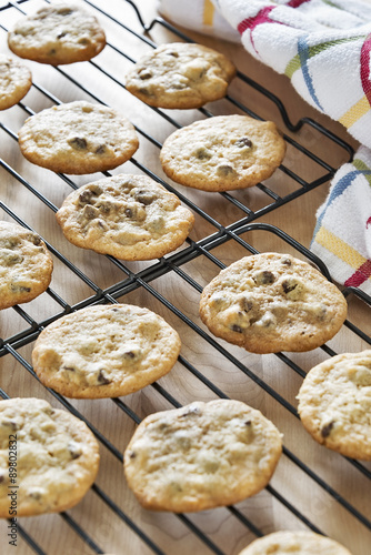 Warm chocolate chip cookies placed on wire racks to cool