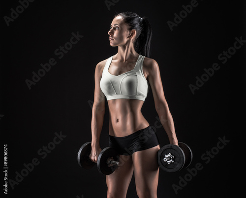 Young woman lifting the dumbbells © bondarchik