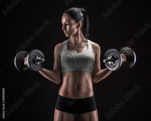 Young woman lifting the dumbbells #89806893