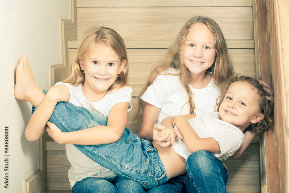 Portrait of happy children which are sitting on the stairs in th Portrait of happy children which are sitting on the stairs in th