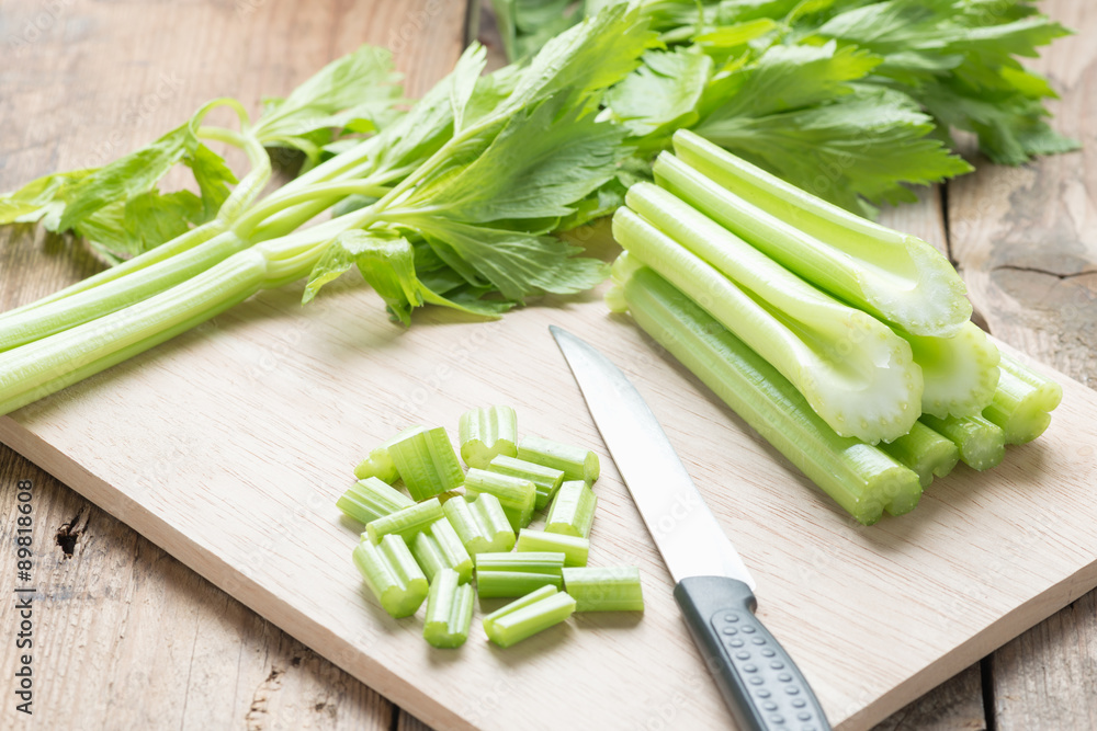 Celery chopped on wooden cutting board with knife. Celery chopped on wooden cutting board with knife.