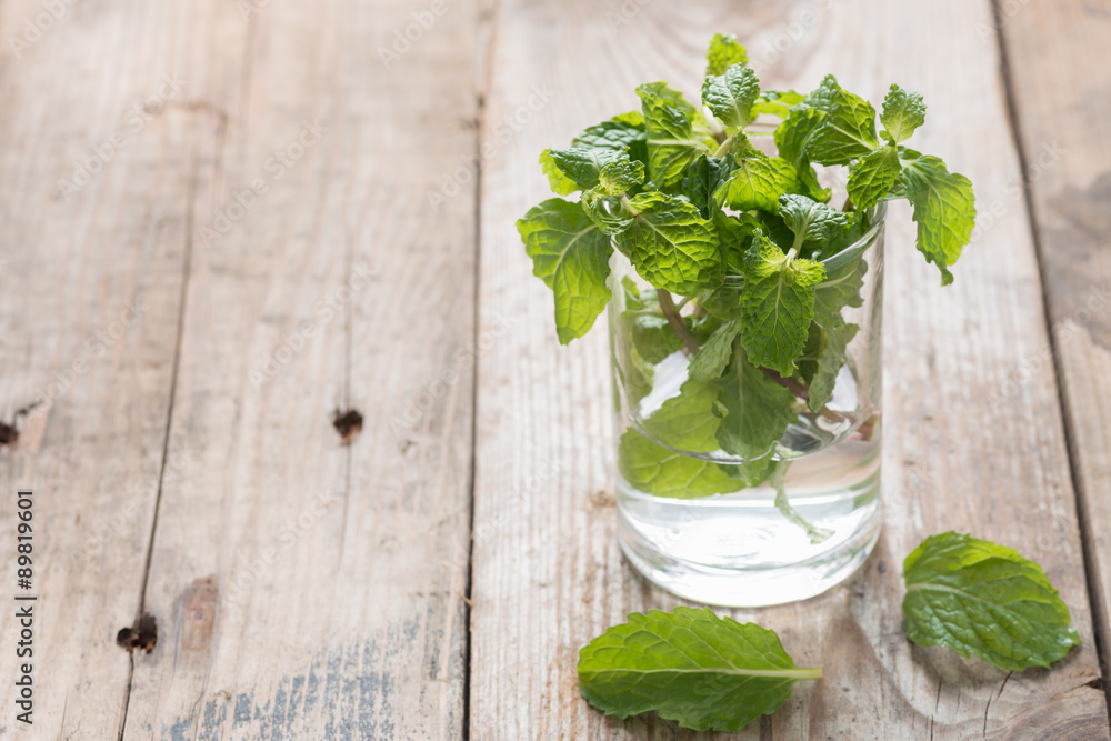 Fresh mint in glass on wood background. Fresh mint in glass on wood background.