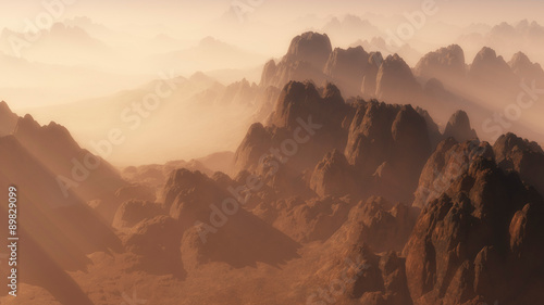 Aerial view of rough mountain landscape in the mist at sunrise.