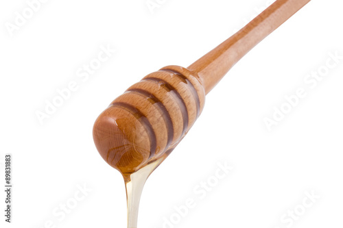 Honey dripping from a wooden dipper
