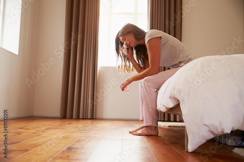Woman Suffering From Depression Sitting On Bed And Crying © Monkey Business