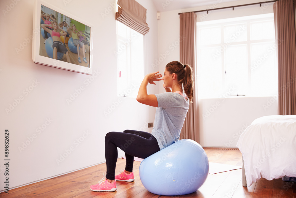 Woman On Ball Working Out To Fitness DVD On TV In Bedroom Woman On Ball Working Out To Fitness DVD On TV In Bedroom