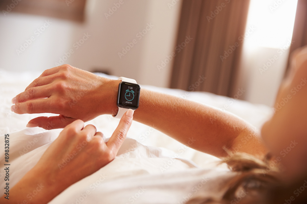 Woman Lying in Bed Woken Up by Alarm Clock App on Smart Watch