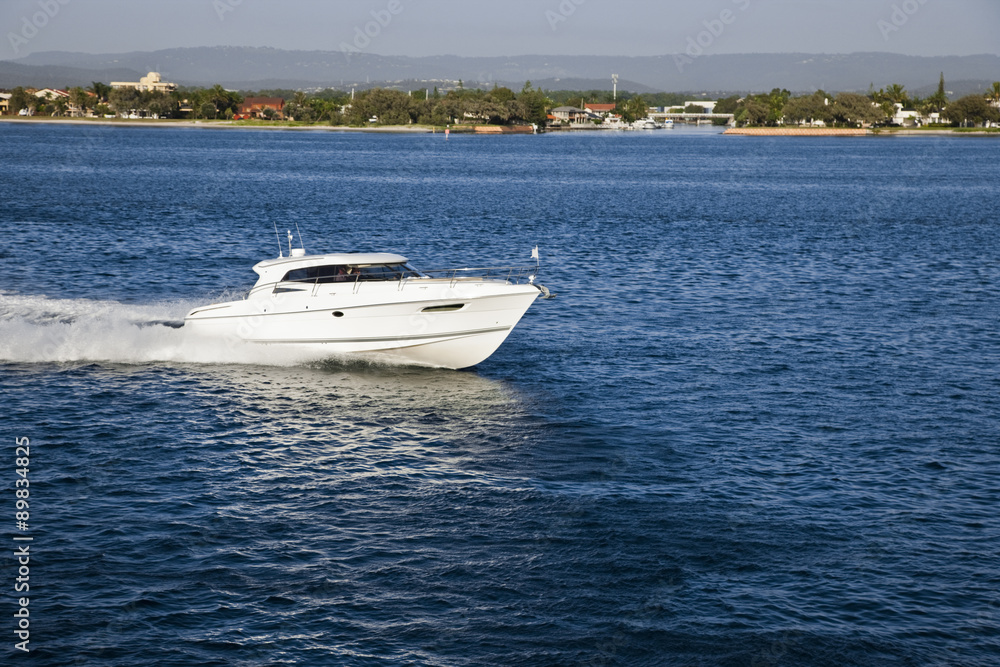 A small motor boat sailing close to the coast A small motor boat sailing close to the coast