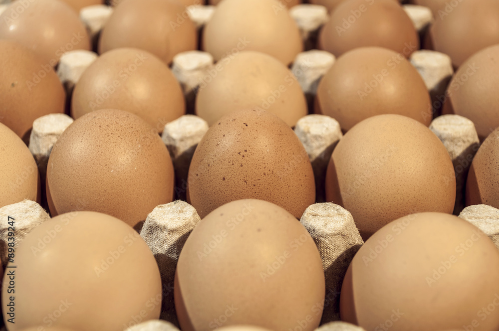 Eggs in carton package on a wooden table for baking, close up Eggs in carton package on a wooden table for baking, close up