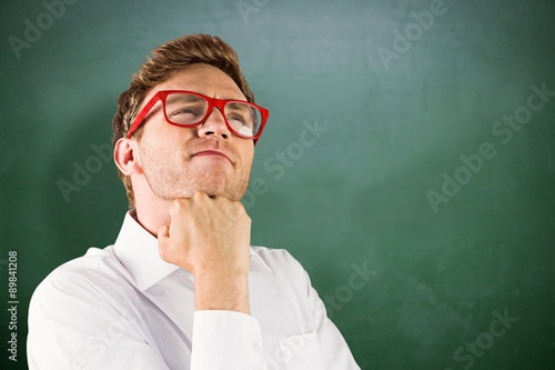 Composite image of young geeky businessman with hand on chin