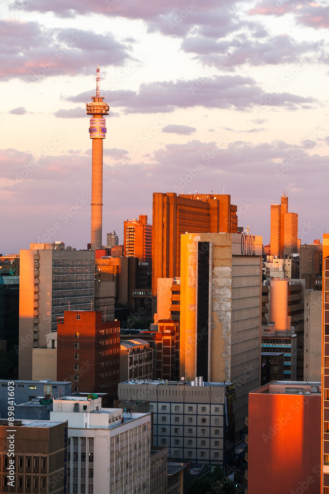 Fototapeta premium Miasto Johannesburg skąpane w popołudniowym słońcu. Zdjęcie budynków i dachów z przedmieść Braamfontein w centrum miasta.