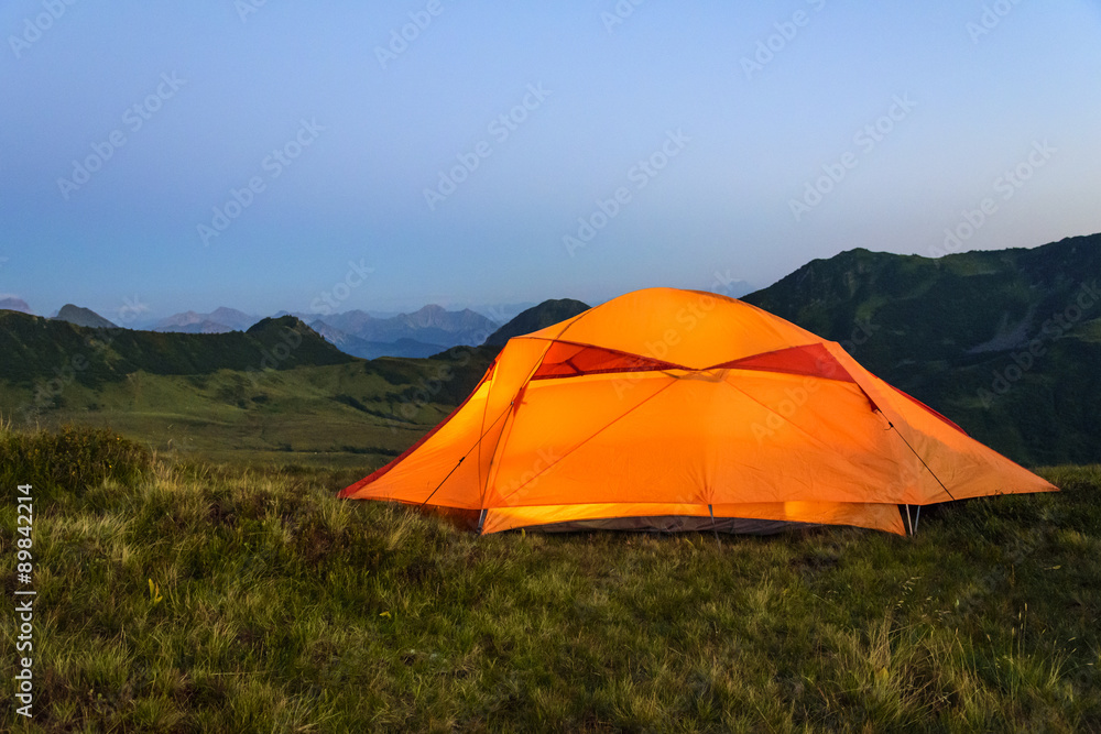 beleuchtetes Zelt in der Abenddämmerung im Gebirge