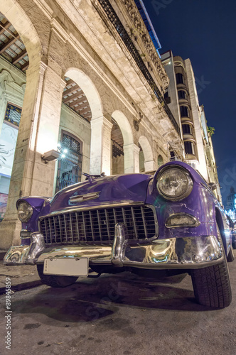 Purple classic car at night in Havana, Cuba