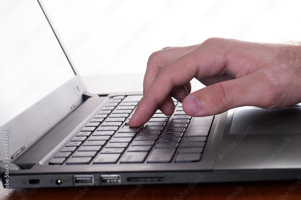 Caucasian man's finger pressing a button of a gray laptop Caucasian man's finger pressing a button of a gray laptop