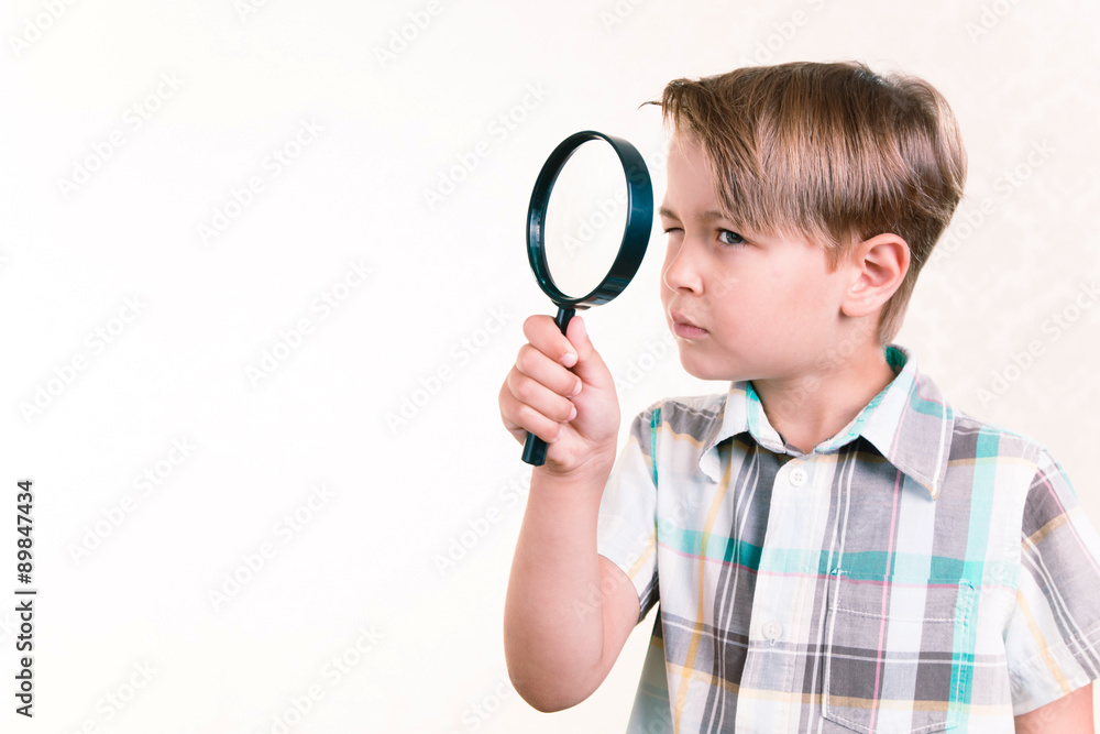 Boy looking through a magnifying glass Boy looking through a magnifying glass
