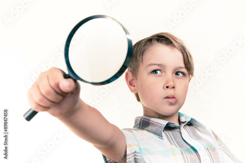 Boy looking through a magnifying glass