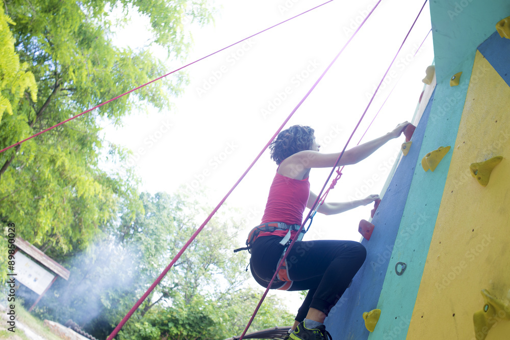 Girl exercise climbing on a artificial rock outdoors Girl exercise climbing on a artificial rock outdoors