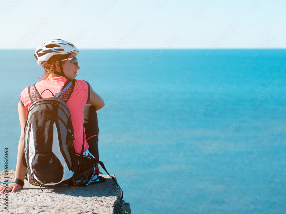 Woman sitting om rock over sea landscape