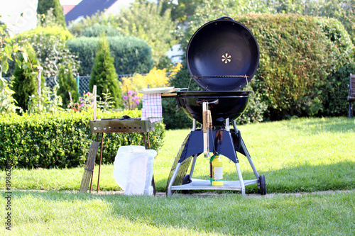 Grill steht im idyllischen Garten einsatzbereit photo