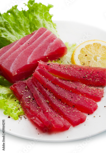 Slices of raw bluefin tuna sashimi on white dish