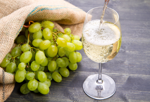 bunch green grapes and wine on wooden background