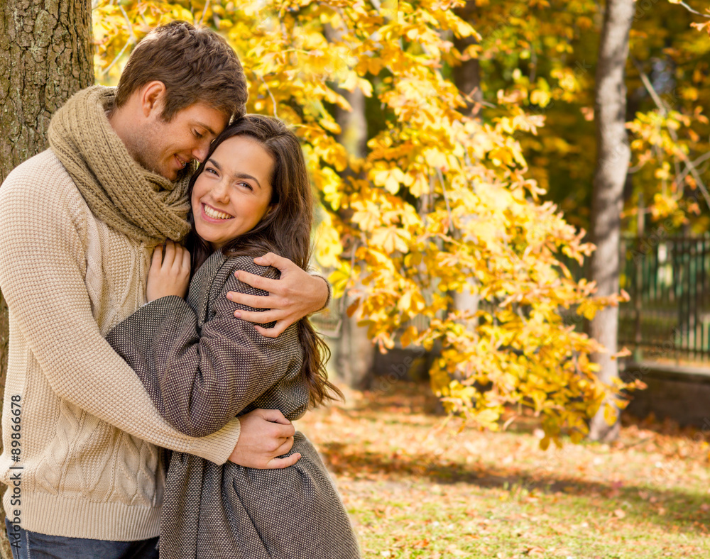 smiling couple hugging over autumn background smiling couple hugging over autumn background