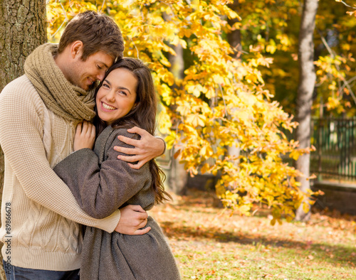 smiling couple hugging over autumn background