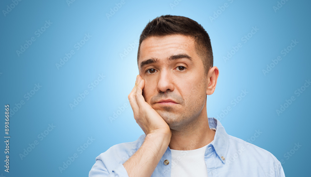 bored middle aged man face over blue background bored middle aged man face over blue background