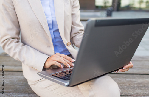 close up of business woman with laptop in city