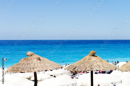 Beach Umbrella made of palm leafs on a perfect white beach