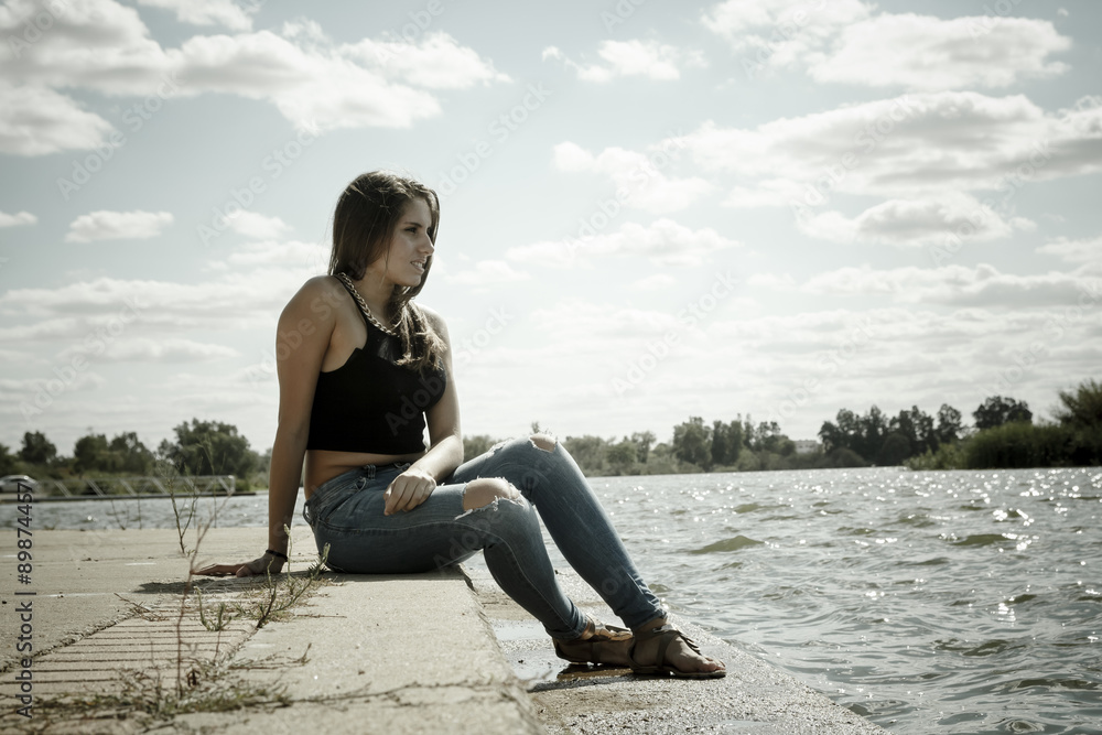 Chica adolescente posando en el embarcadero. Adolescente rubia de quince años como modelo. Chica rubia de pelo largo al lado del rio en verano. Chica adolescente posando en el embarcadero. Adolescente rubia de quince años como modelo. Chica rubia de pelo largo al lado del rio en verano.