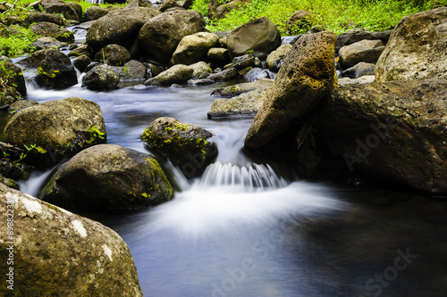 A tranquil steam forming unique patterns as it flows among the rocks.  
