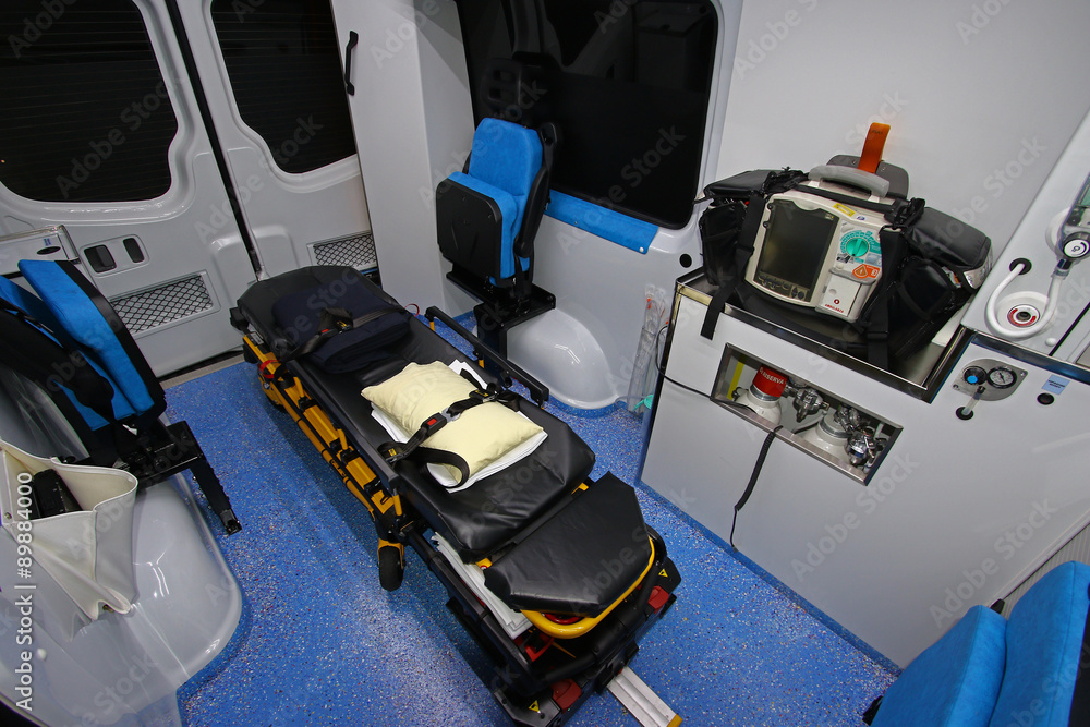 Interior of a modern ambulance with stretcher,heart monitor,defibrillator,oxygen,lights,night
