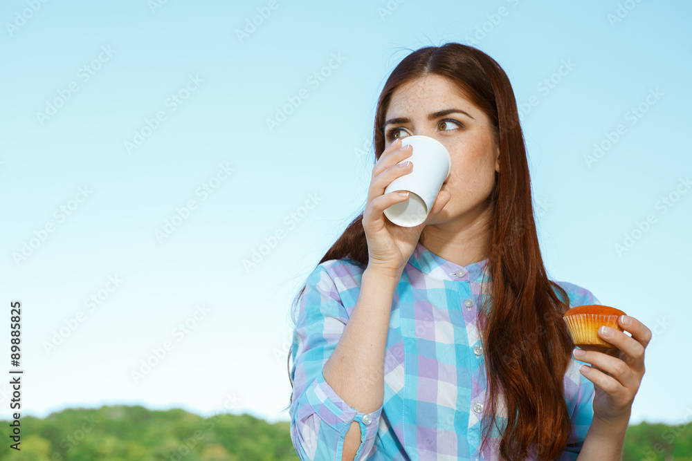 Pretty young woman drinking coffee at the park Pretty young woman drinking coffee at the park