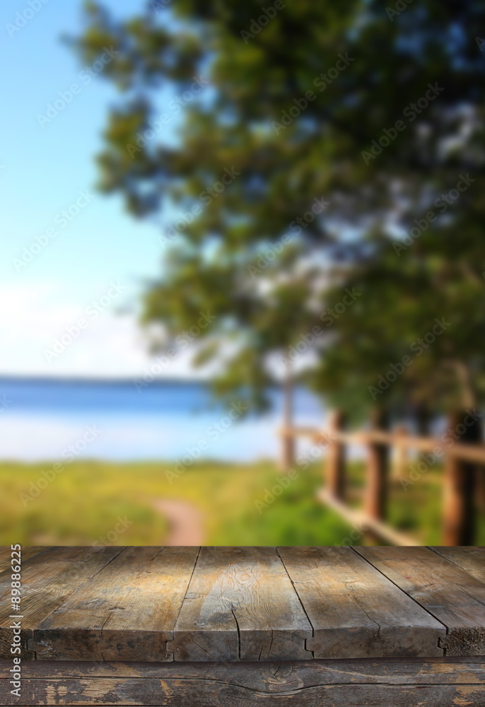 Vintage wooden board table in front of dreamy and abstract forest lake landscape