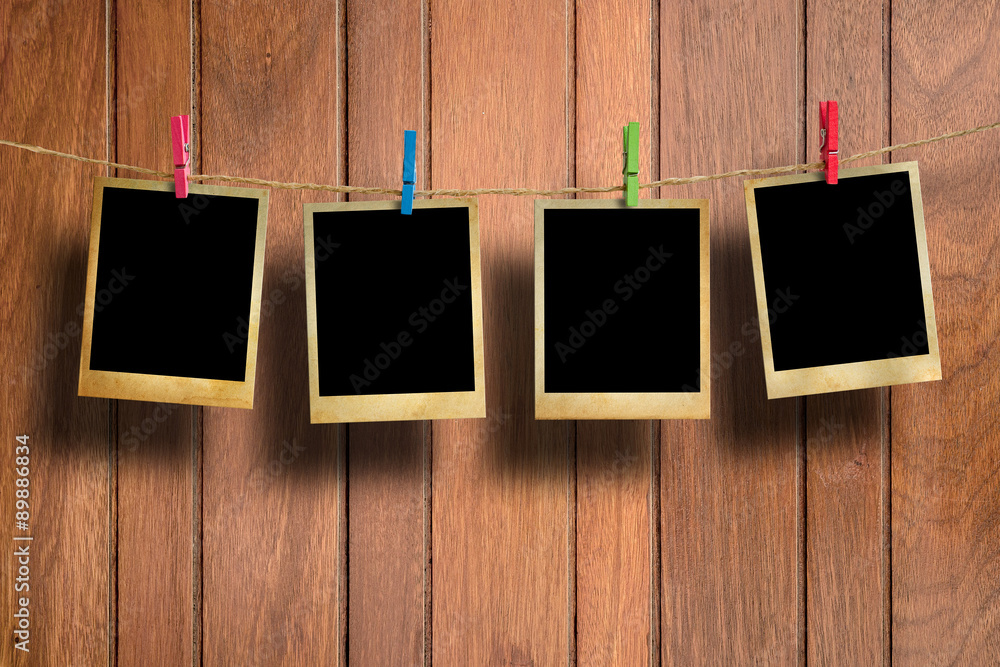 Old picture frame hanging on clothesline on wood background. Old picture frame hanging on clothesline on wood background.