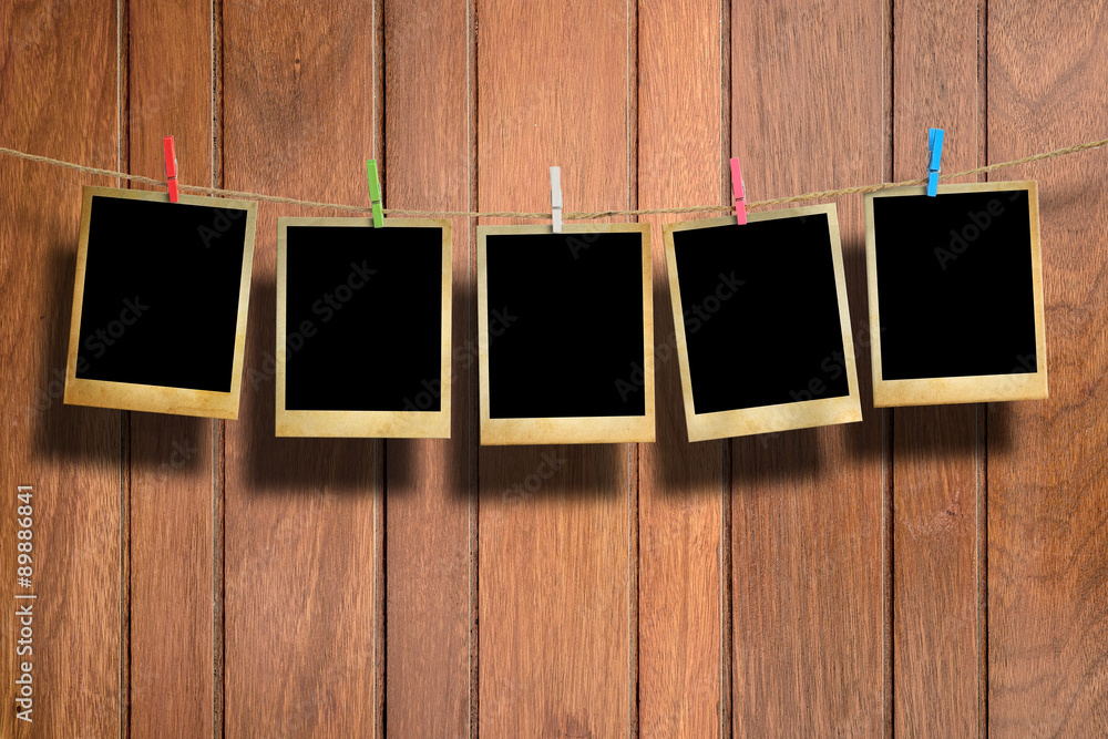Old picture frame hanging on clothesline on wood background. Old picture frame hanging on clothesline on wood background.
