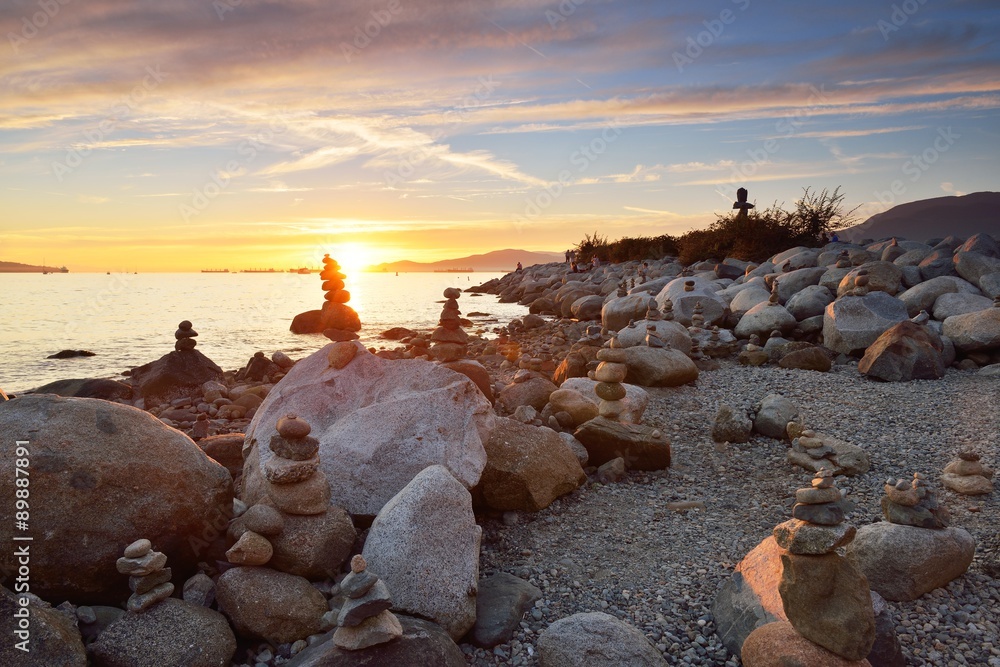 Balanced rock sculptures at English Bay during sunset