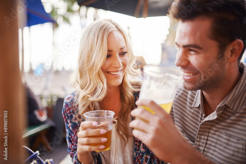 Photographie happy couple drinking beer together at outdoor pub or bar